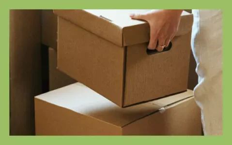 Person lifting a cardboard box with flat sides ideal for barcode placement